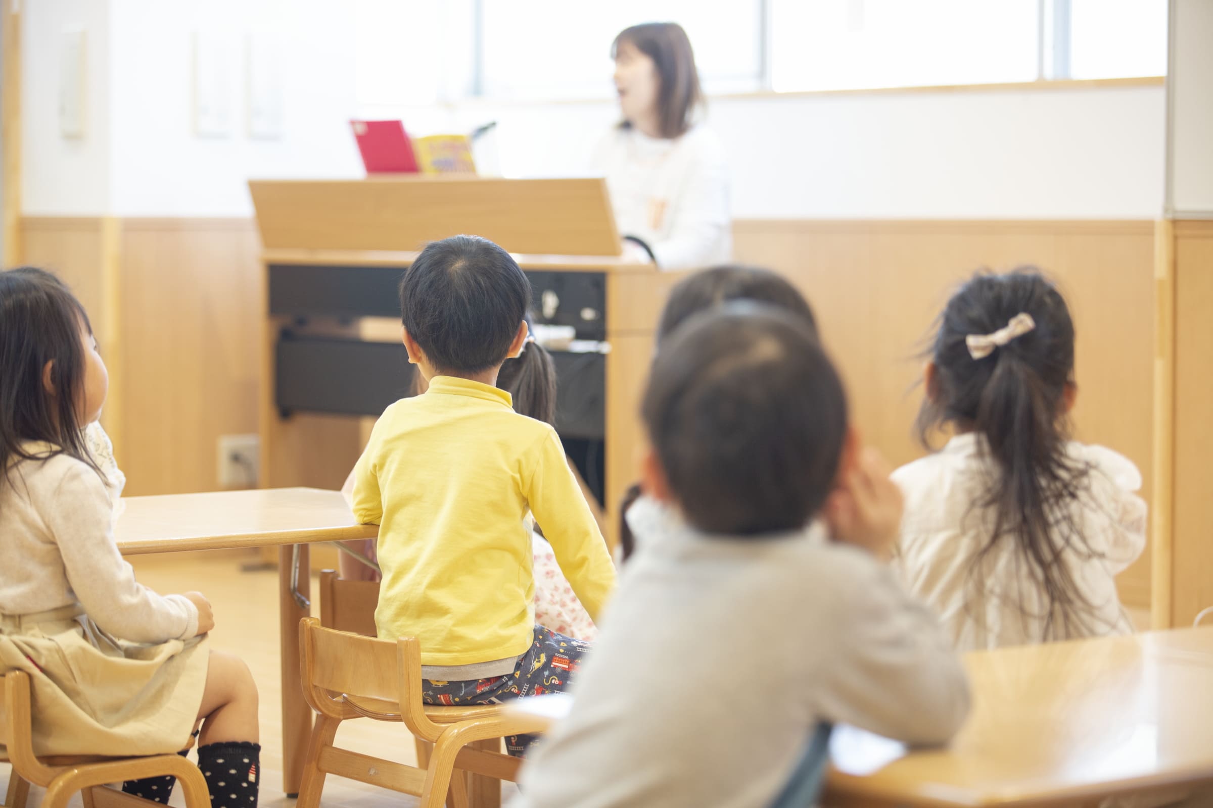保育室で子どもたちに話す職員