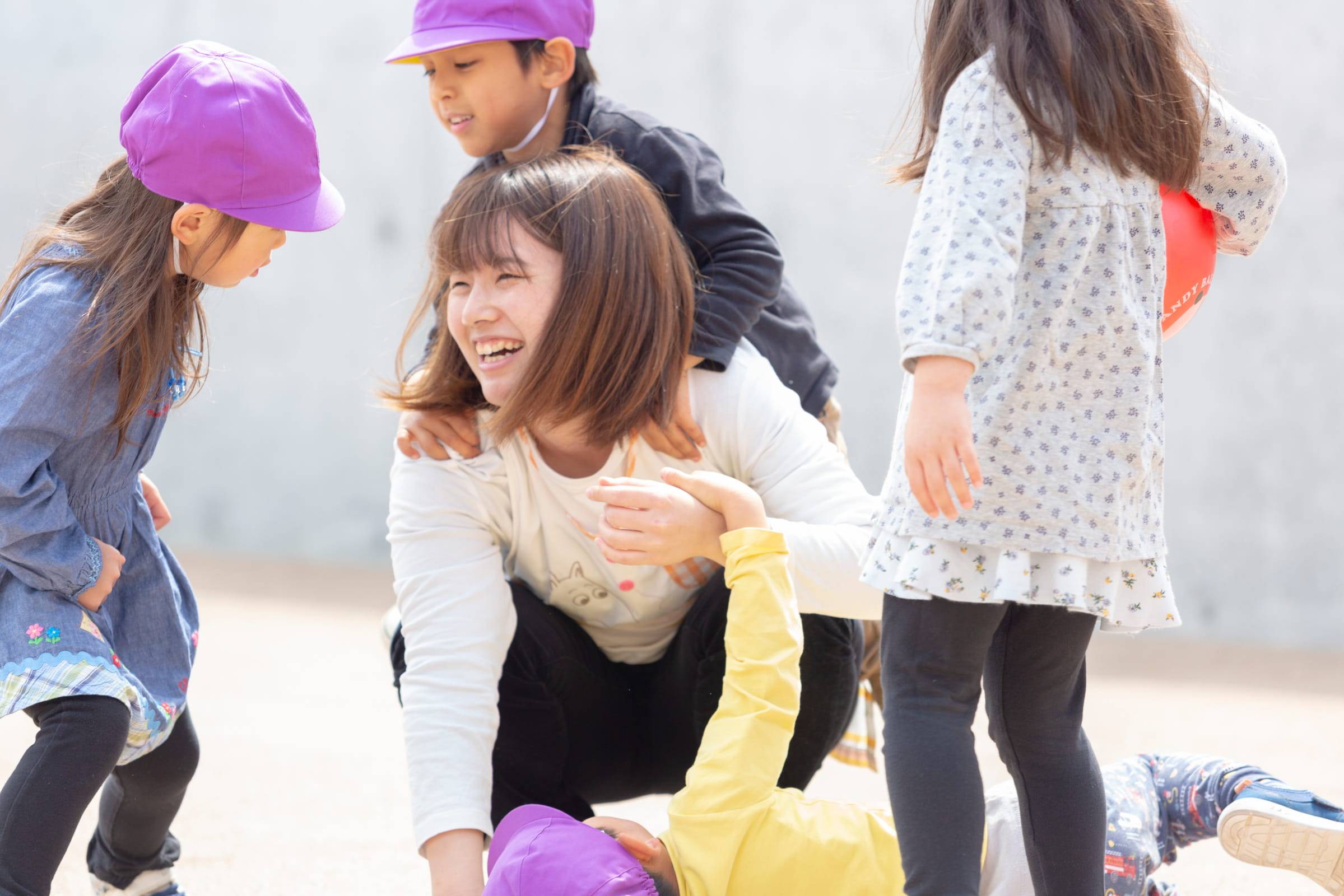 園庭で子どもたちと関わる職員