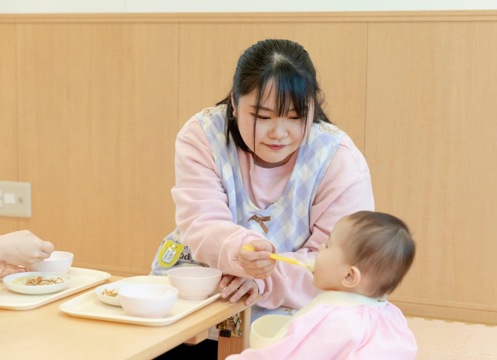 子どもの食事を見守る職員