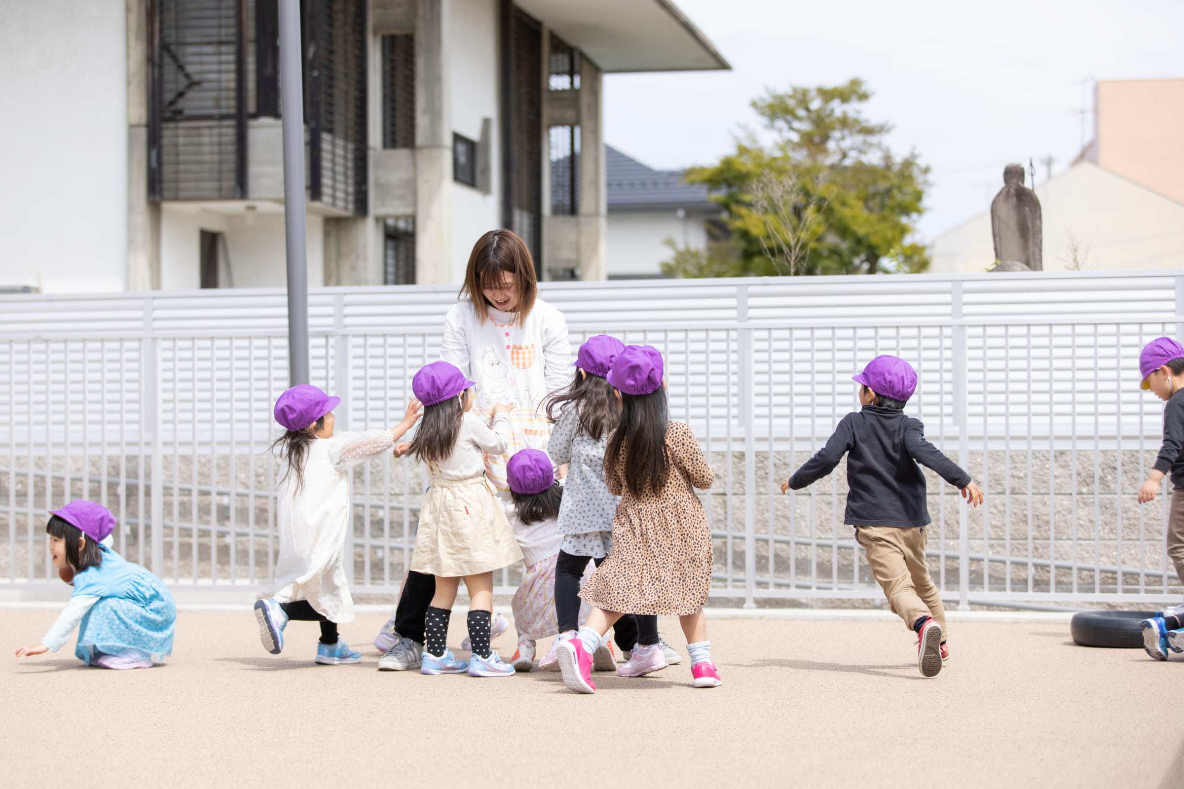 園庭で遊ぶ子どもたちと職員