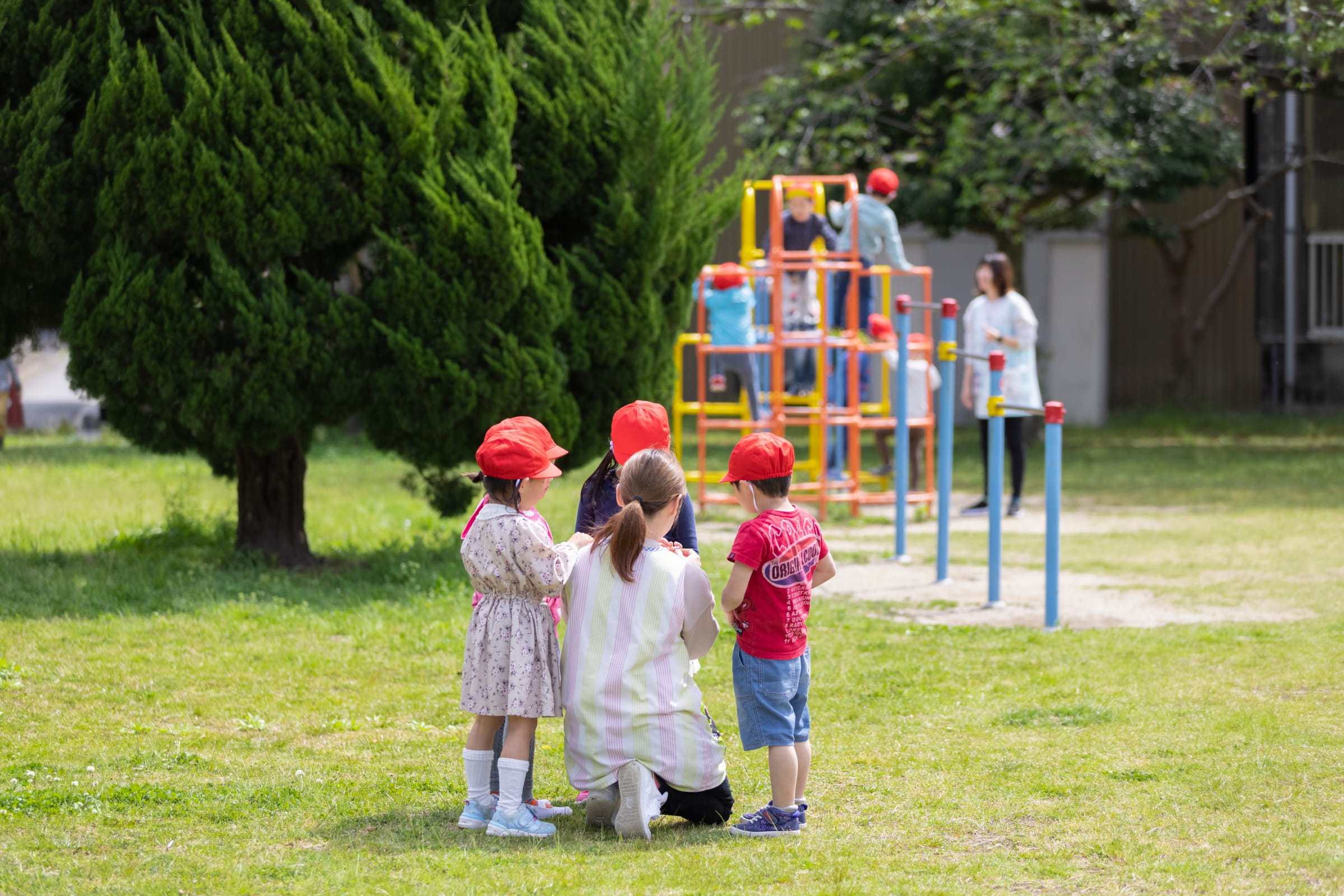 園庭の遊具で遊ぶ子どもたち