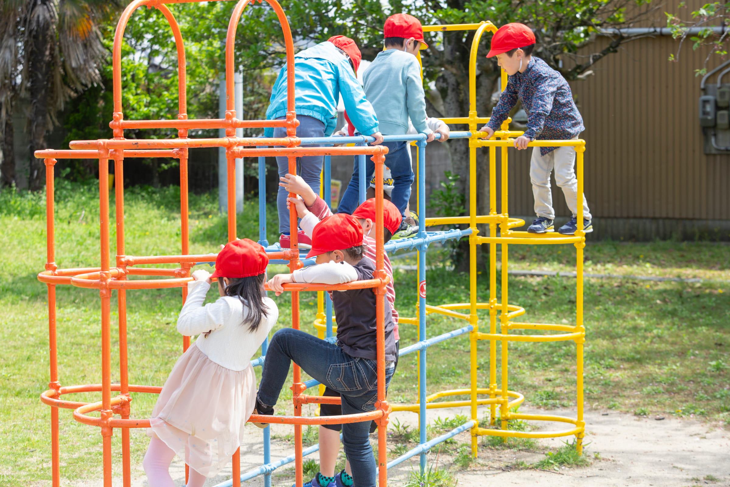 園庭の遊具で遊ぶ子どもたち